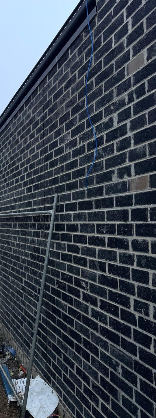 Large blank brick elevation before cleaning, with mortar haze in vertical streaks